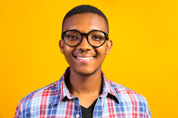 Young handsome man of african american ethnicity wearing checkered shirt posing over isolated background. Portrait of stylish confident male in casual outfit. Close up, copy space.