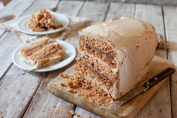 Homemade dacquoise cake with nuts and buttercream on wooden table