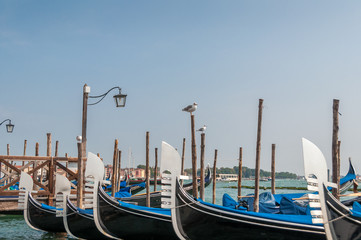 Fototapeta premium Traditional Venetian gondolas at pier. Travel Italy tourism background