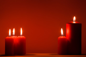 red burning candles on a red background. Christmas background.