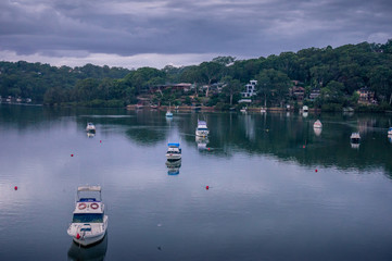 Yachts and fishing boats in lagoon at dusk