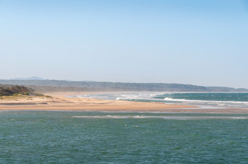 Summer beach landscape with sand coastline and mild waves