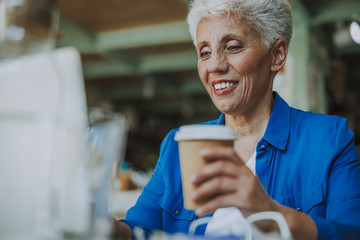 Happy lady with coffee and laptop smiling stock photo