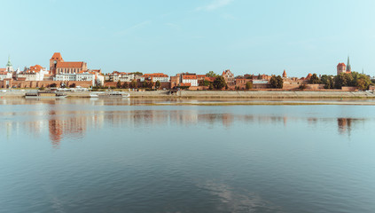 Fototapeta na wymiar Torun. View from behind the Vistula River to the old medieval city walls and architecture. Poland