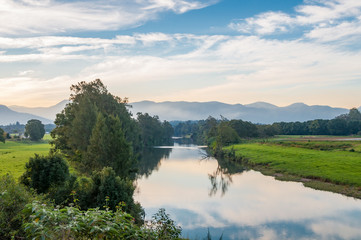 Morning nature landscape with freshwater river and mountains in the distance - obrazy, fototapety, plakaty