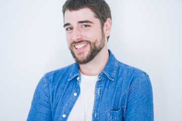 Fototapeta premium Young handsome hispanic man smiling at the camera looking happy and confident over isolated white background