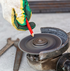 A worker sharpens a pencil at a construction site