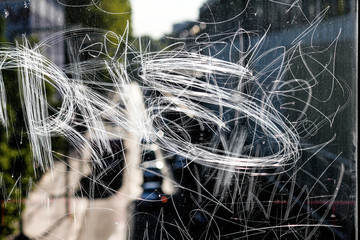 detail of a graffiti engraved on a transparent glass in Berlin, Germany - 289840337