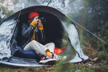 photographer tourist traveler take photo on camera in camp tent in foggy rain forest, hiker woman shooting mist nature trip, trekking tourism, rest vacation concept camping holiday