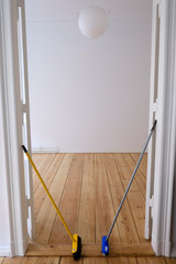 Besen und Schrubber vor einem leeren Zimmer