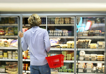 Man choosing frozen food from a supermarket freezer