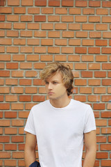 Teenager standing near a brick wall