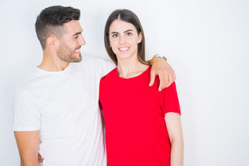 Obraz premium Young beautiful couple in love hugging over white isolated background