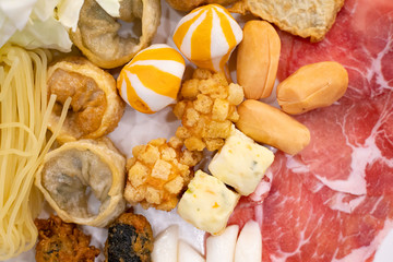 Ingredient food for Budae Jjigae, Korean hotpot, that have Kimchi, spam, sausages, pork, tofu, crispy wonton, ramen noodles and tokpokki
