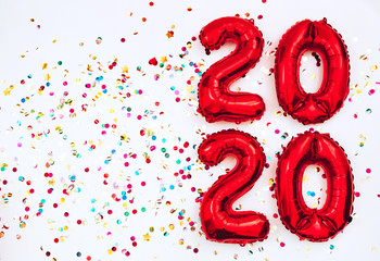 Fototapeta premium 2020 happy new year in the form of red balloons isolated on white background. scattered confetti on a white background. Christmas card. gel balls in the form of numbers 2020. holiday atmosphere.