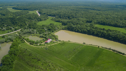 Aerial landscape nature - Dense green forest, green meadows, lake in southern Russia