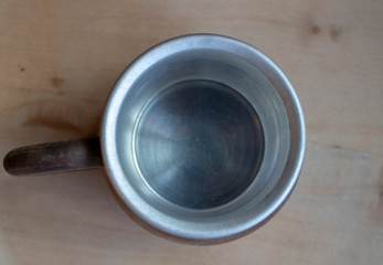 Metallic mug shot from the top. The base and the top of the cup are wooden.