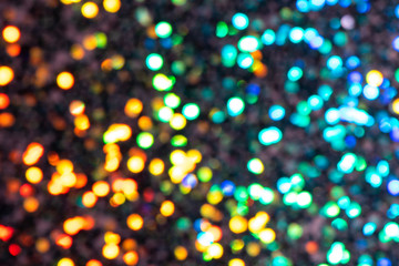 Naklejka premium Colorful prism confetti blurred festive bokeh backdrop, trendy sparkles and glitter background, flat lay. Christmas and holidays concept, 2020 new year celebration