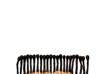 A row of burnt matches on a white background. Forest fire concept.