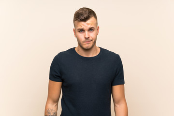 Fototapeta premium Young handsome blonde man over isolated background with sad and depressed expression