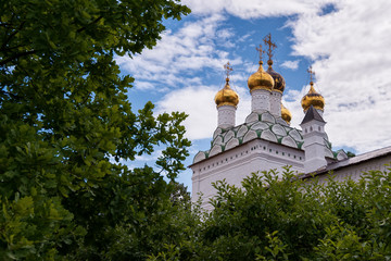 Fototapeta na wymiar View of the temple with domes against the sky and trees. Russian shrines. Joseph-Volotsky Monastery in Teryaev. Moscow region, Teryaevo.