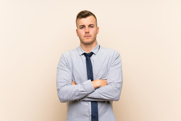 Young blonde businessman over isolated background keeping arms crossed