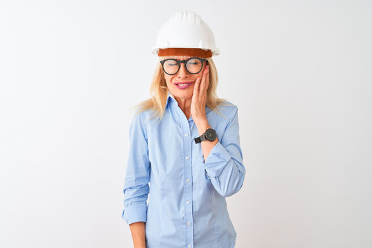 Middle age architect woman wearing glasses and helmet over isolated white background touching mouth with hand with painful expression because of toothache or dental illness on teeth. Dentist concept.