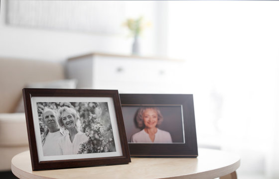 Portraits in stylish frames on table indoors
