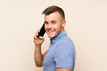 Happy Young blonde man using mobile phone