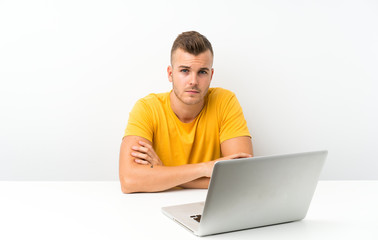 Young blonde man in a table with a laptop