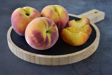 Naklejka na ściany i meble Tender, velvety peaches with juicy pulp on a wooden cutting board 