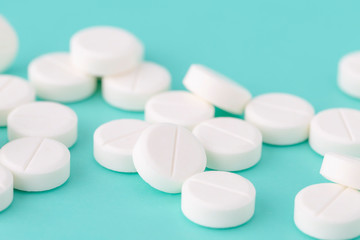 White round pills close-up on a colored background