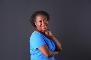 Portrait of happy African-American woman on black background