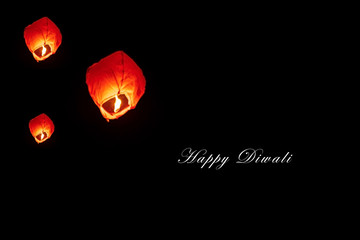 Happy Diwali - Fireflies Lantern. Diwali red sky Lanterns at night with space for text. People releasing sky lanterns to worship. Paper lamps flies up highly in the sky.