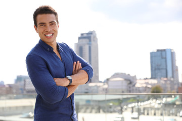 Handsome young African-American man on city street. Space for text