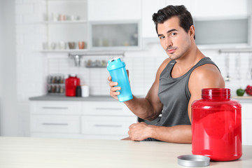 Young athletic man with protein shake powder in kitchen, space for text