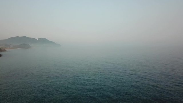 海原を進む　海沿いの道　青い海　朝靄　順光　空撮　低高度　前進　v08