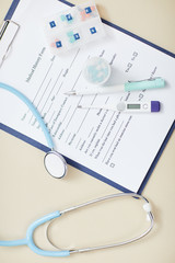 Top view background of medical form on clipboard with stethoscope over it, copy space healthcare concept