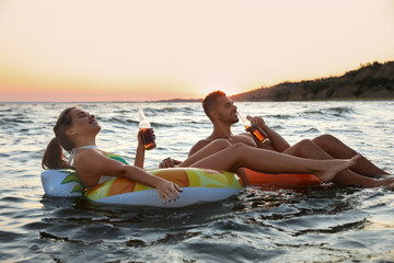 Happy young couple on inflatable rings in water