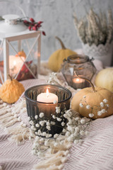 autumn cosy tea on tray with pumpkin, candles and blanket