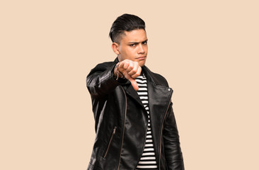 Young man showing thumb down with negative expression over isolated background