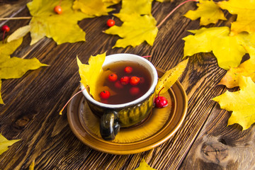 Yellow fallen maple leaves on wooden texture background.