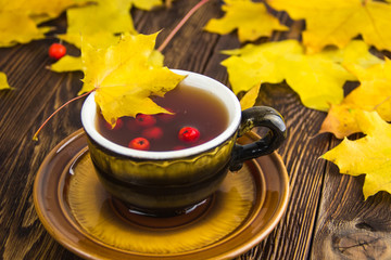 Yellow fallen maple leaves on wooden texture background.