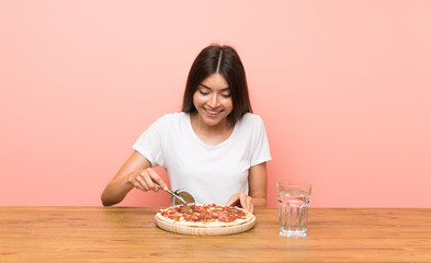 Young woman with a pizza in a table