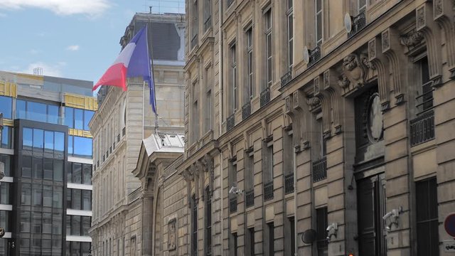 flag of France and the European Union waves in the wind of a historic building against the backdrop of a modern building. Slow Motion.
