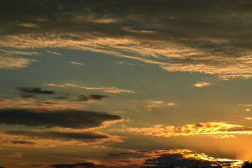 blue sky with clouds in the rays of the setting sun