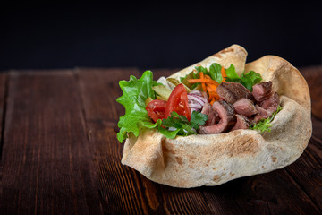 Turkish and Arabic Traditional Ramadan mix kebab plate. Kebab beef on lavash bread with sauce and vegetables.