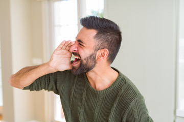 Obraz premium Man shouting with rage covering mouth with hands, yelling frustrated and crazy