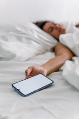 woman sleeping in bed phone in her hand
