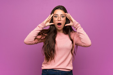 Teenager girl over purple wall with surprise expression
